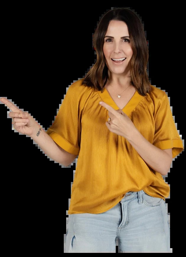 Lisa Chastain professional photo in mustard yellow top and jeans pointing to the right